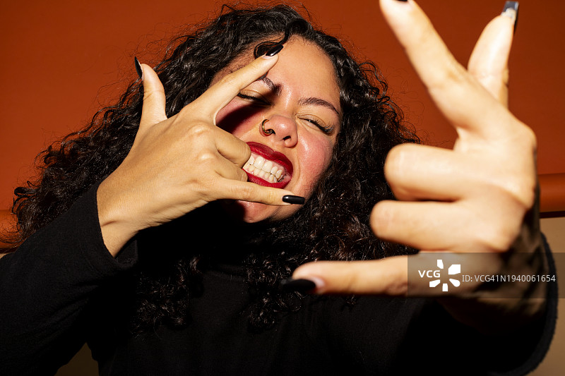 态度酷炫、做着夏威夷手势的年轻女人图片素材