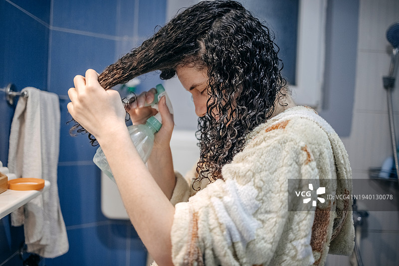 年轻女子洗发后吹干头发图片素材