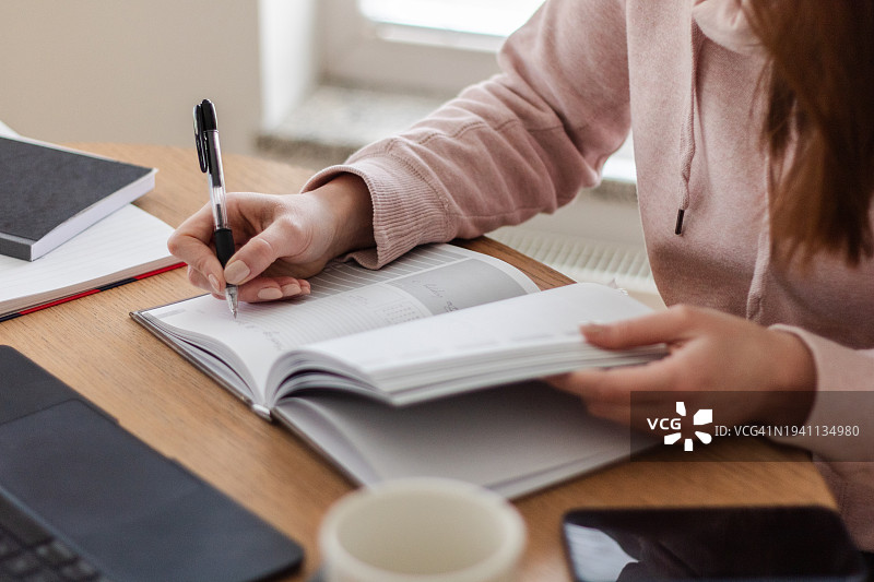 年轻女人在计划本上书写特写图片素材