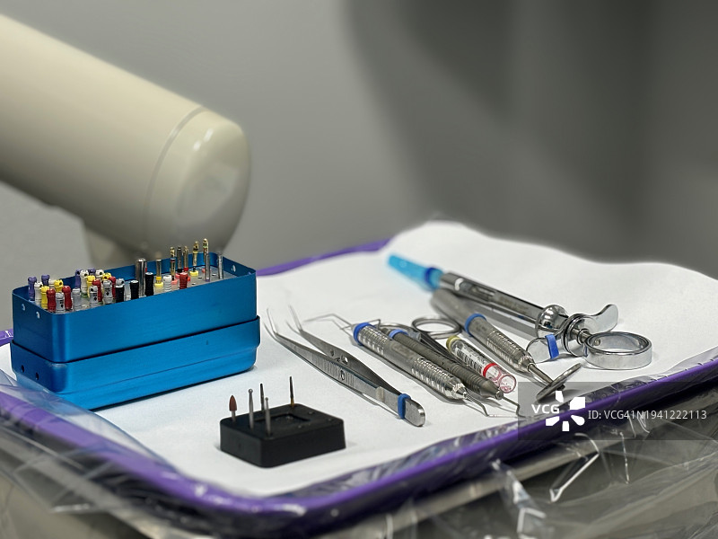 牙科托盘与牙科器械和工具：口腔镜、镊子、Hollenback雕刻器、Westcot充填器、牙周探针、棉钳、根管钻、锉和扩孔钻，以及抽吸注射器图片素材