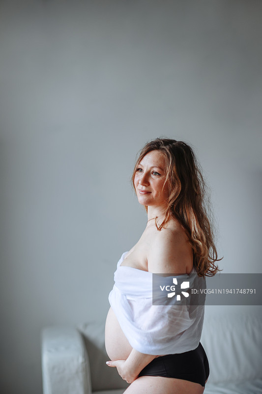 真诚时刻：中年孕妇的白色床单情感写真，怀孕摄影图片素材