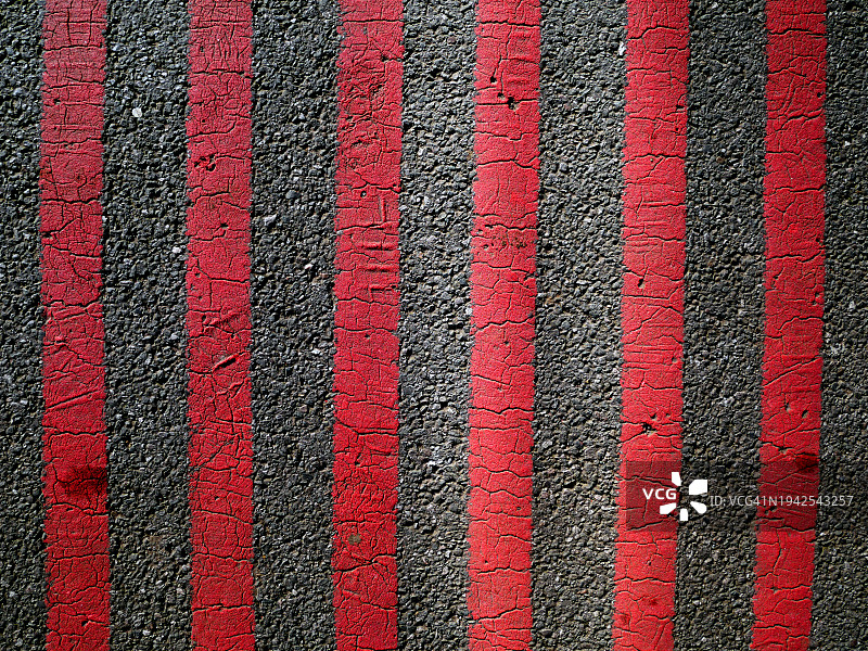 英国伦敦街道沥青路面上带有风化效果的红色线条图片素材