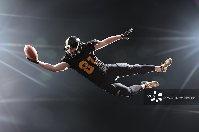 足球运动员在烟雾背景中跳跃接球图片素材