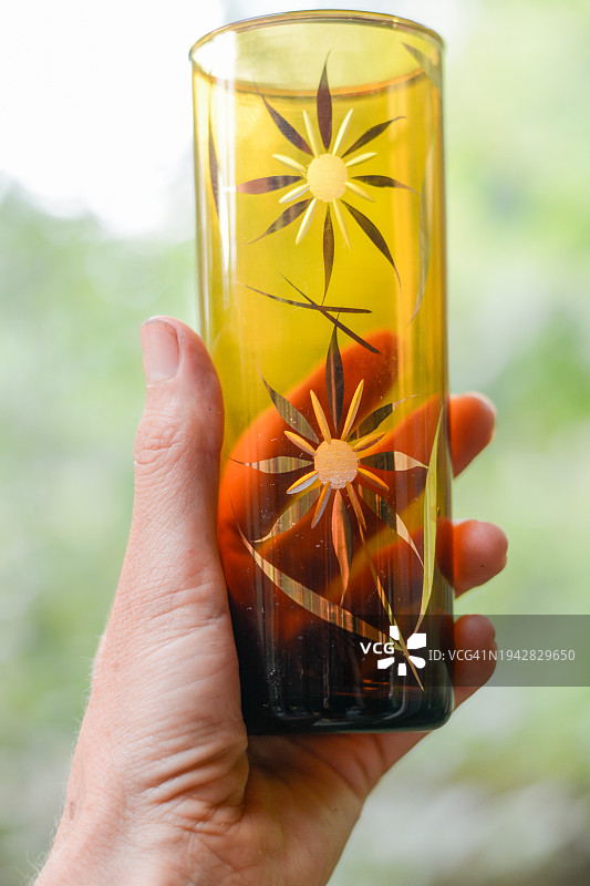 女人手持复古琥珀玻璃杯图片素材