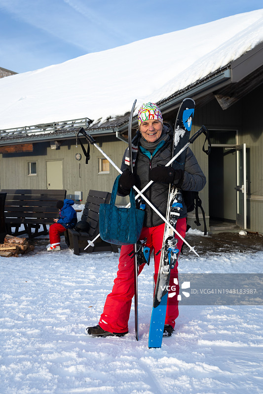 运动后，拿着滑雪装备摆姿势的女人图片素材