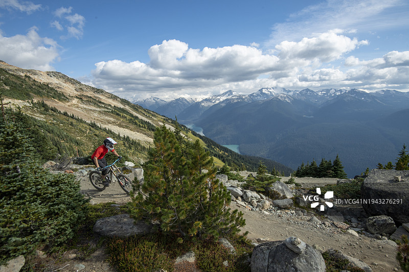 山地自行车手从山上沿着岩石小径骑行图片素材
