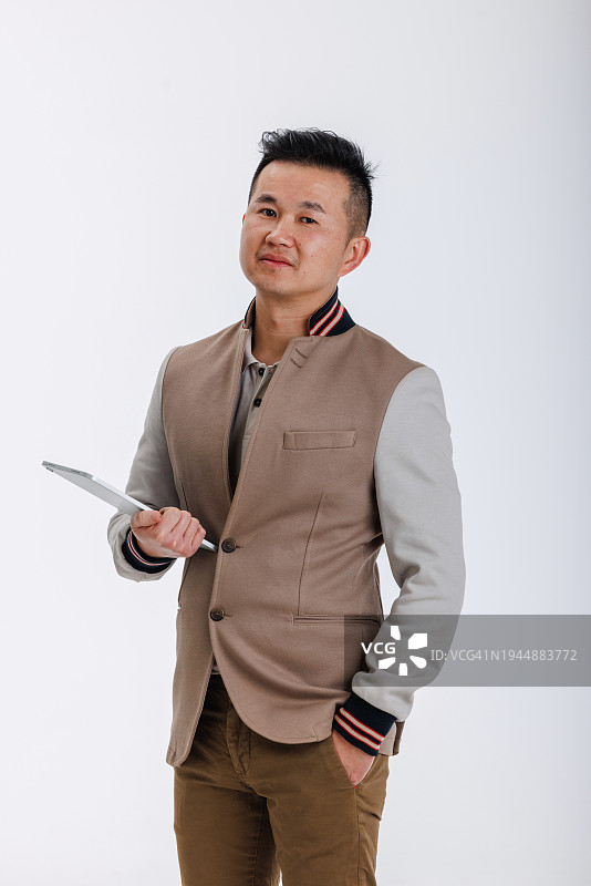在演播室里拿着平板电脑的自信中国商人图片素材