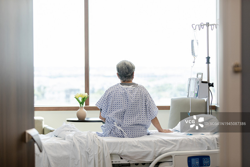 一位老年人坐在医院病床上的背影图片素材