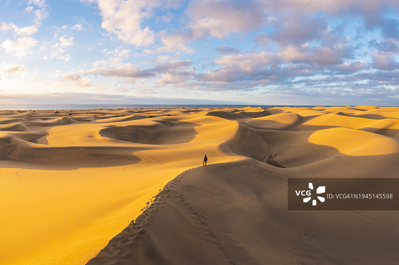 西班牙日落时分沙丘顶部的游客图片素材