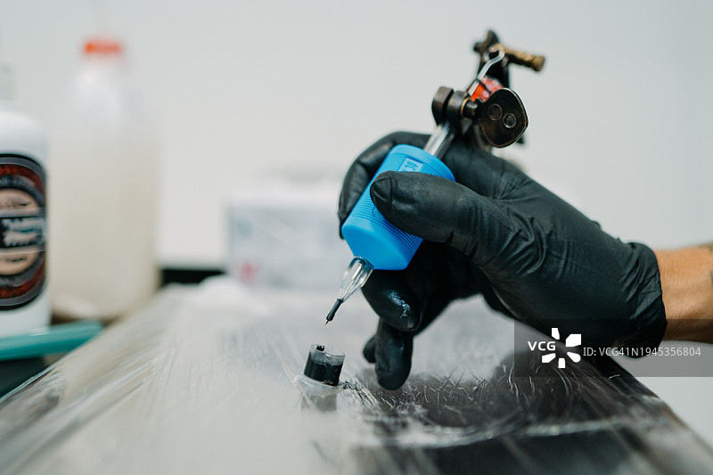 男纹身师蘸墨水特写图片素材