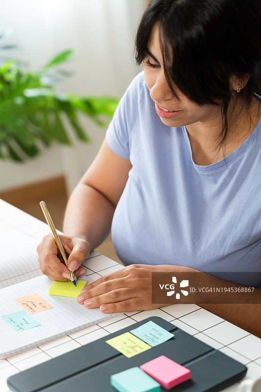 在桌旁纸上书写的女人图片素材