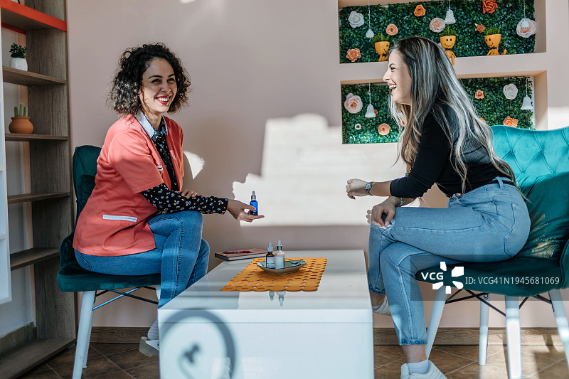 美丽的女人展示面部精华液图片素材