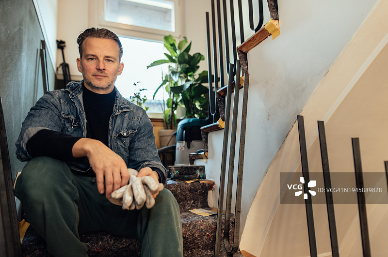 男人在家中楼梯上进行DIY装修的肖像图片素材