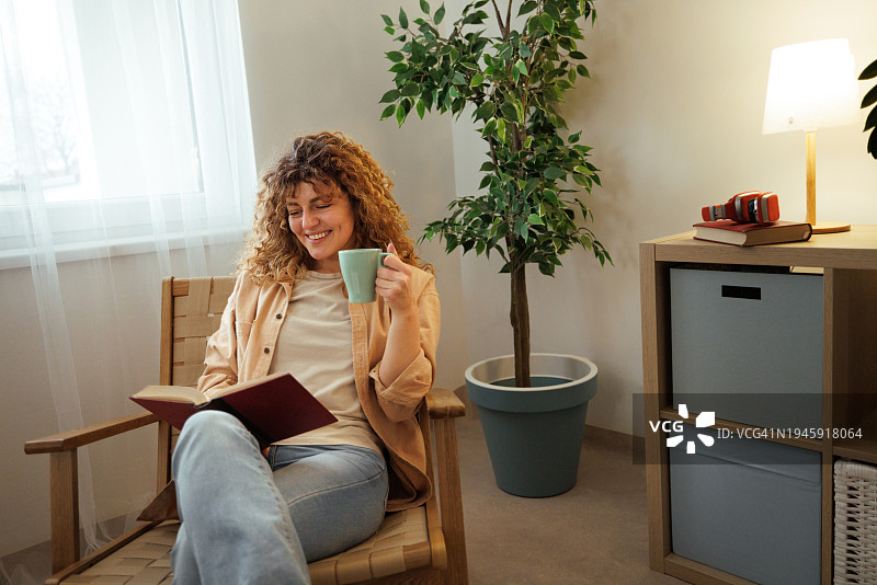 年轻漂亮的女人在家喝咖啡看书图片素材