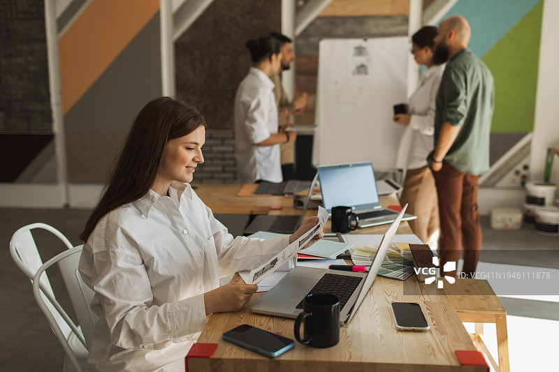 快乐的客户与设计师在店内办公室讨论房屋灰泥外观的材料样品细节图片素材