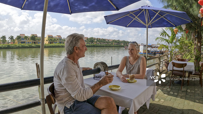 中年夫妇在户外咖啡馆享用饮品图片素材