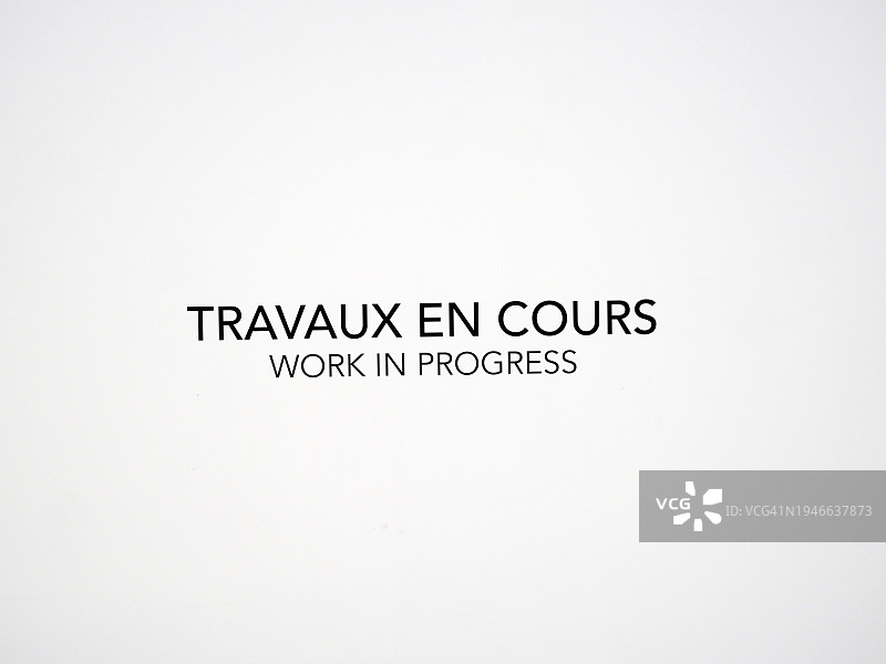 巴黎建筑工地围墙上的法语和英语“施工中”标语图片素材