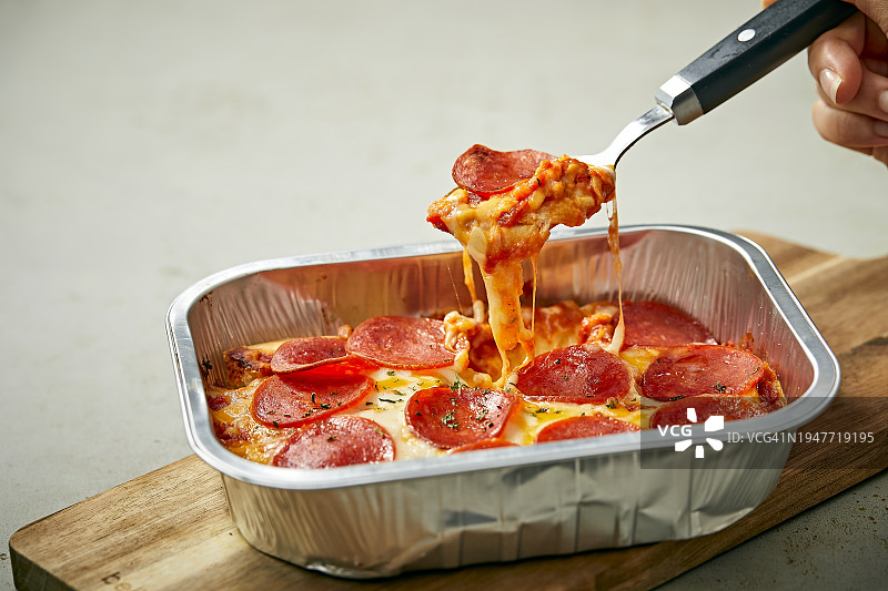 用勺子吃意大利辣香肠披萨图片素材