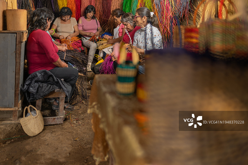 女工匠在她们的工作室里制作芦苇包图片素材