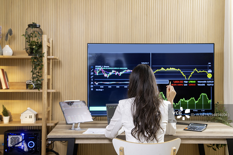 金融分析师在多显示器工作站上分析实时股票的肖像图片素材