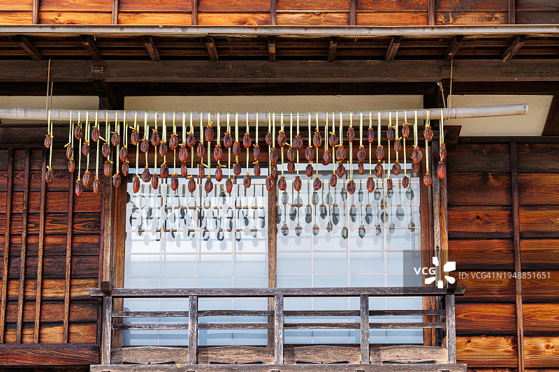 日本岐阜县木屋窗户上悬挂的柿子干图片素材