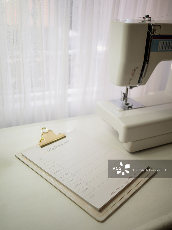 缝纫机旁的每日任务笔记本图片素材