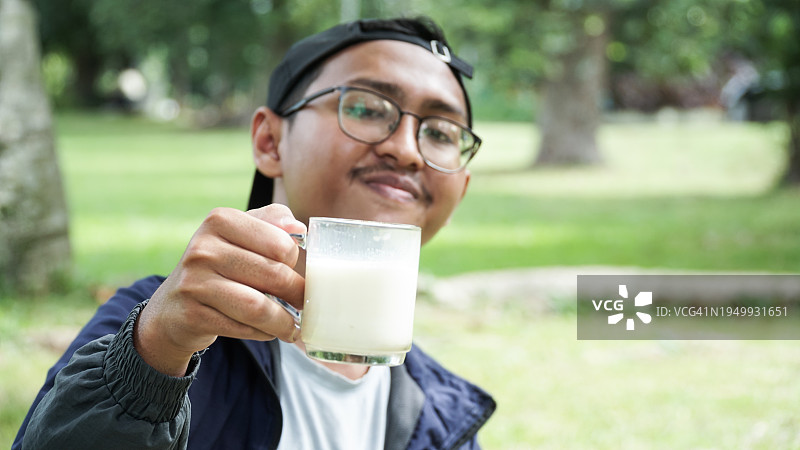 年轻男人在农田里喝牛奶欢呼图片素材