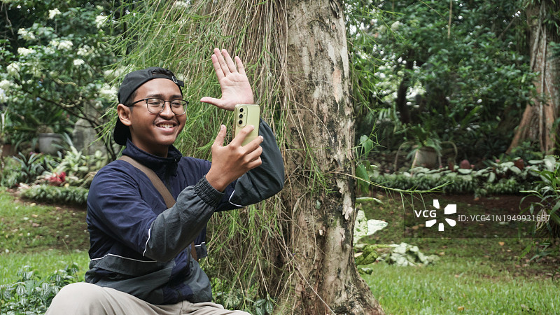 在公园用手机拍摄Vlog的视频博主图片素材