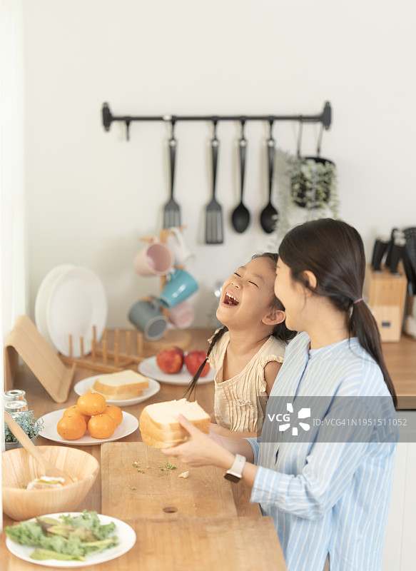 亚洲母女在厨房一起做饭图片素材