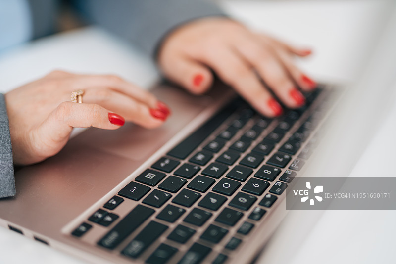 女性手部特写：在笔记本电脑上打字图片素材