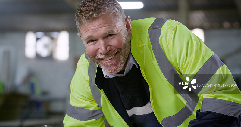 快乐的男人，肖像，建筑工程师在建筑工地规划职业。男性承包商或建筑师面带微笑，身穿工作服或反光夹克图片素材