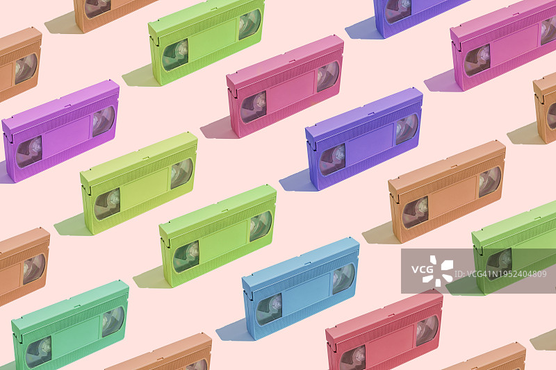 粉色背景上的彩色VHS录像带静物图片素材