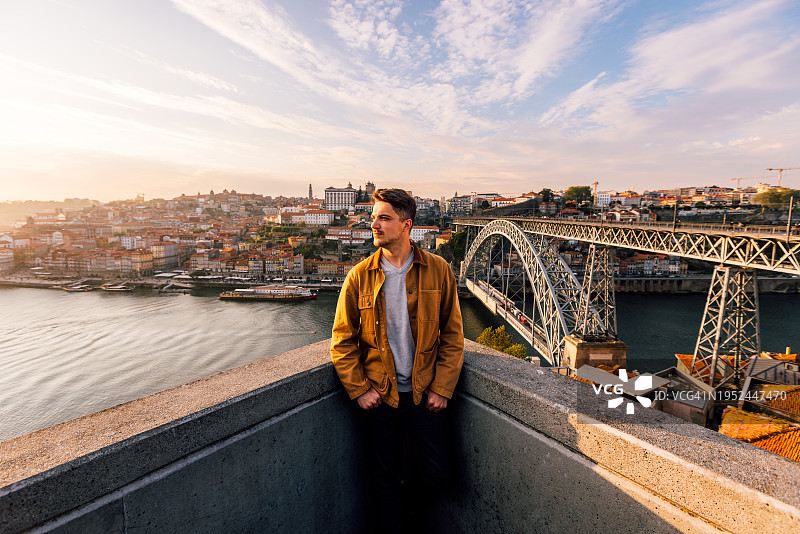 男人从上方看着日落时分的波尔图老城城市景观，葡萄牙波尔图图片素材