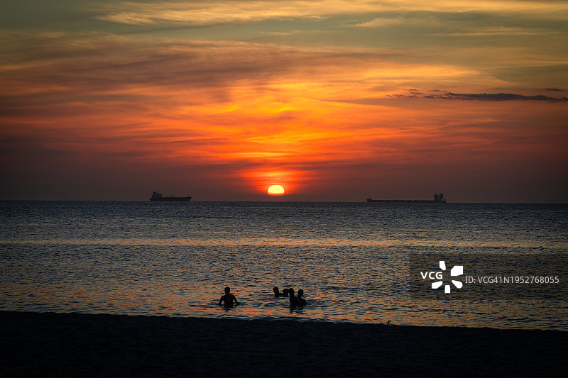 日落时分海滩上的人物剪影图片素材