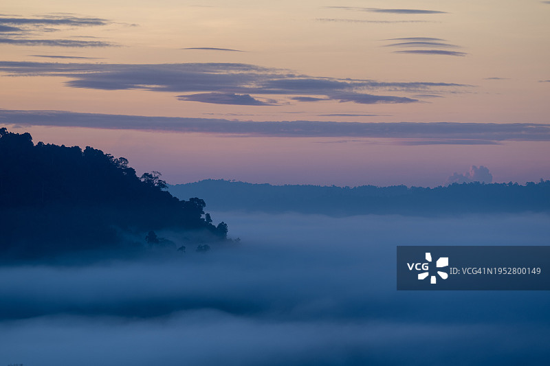 日落时群山映衬天空的剪影图片素材
