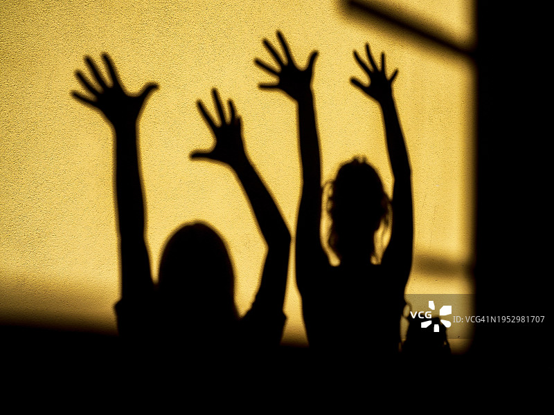 墙上四个交叉手臂的阴影图片素材