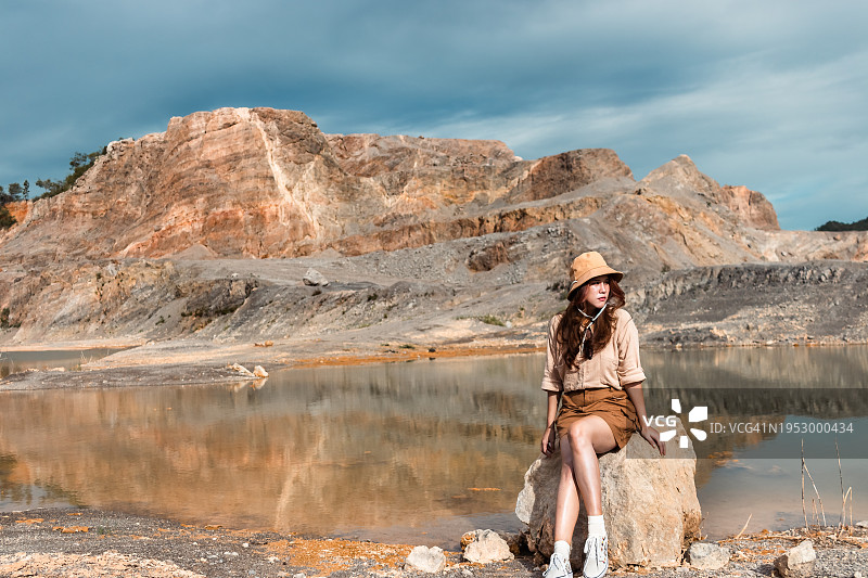 女人坐在湖边岩石上图片素材
