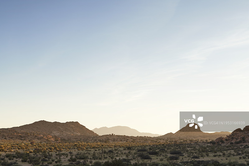 阳光明媚的日子里，天空广阔的岩石沙漠景观图片素材