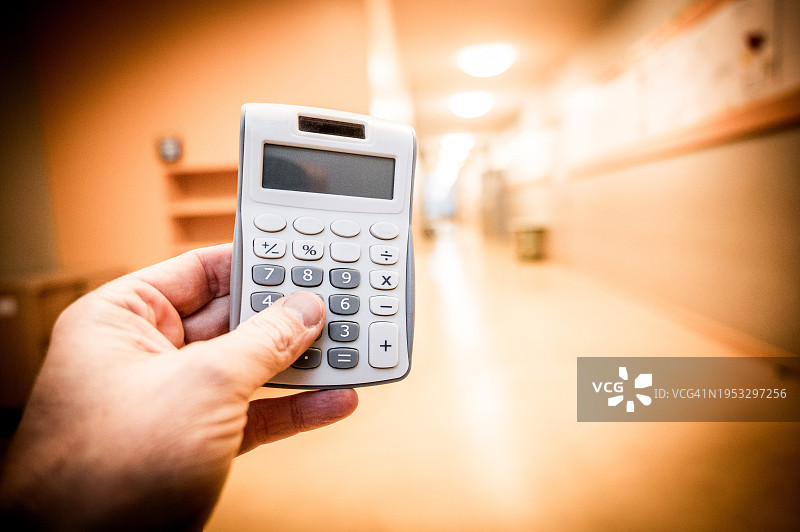 人物在教育中心走廊使用计算器计算图片素材