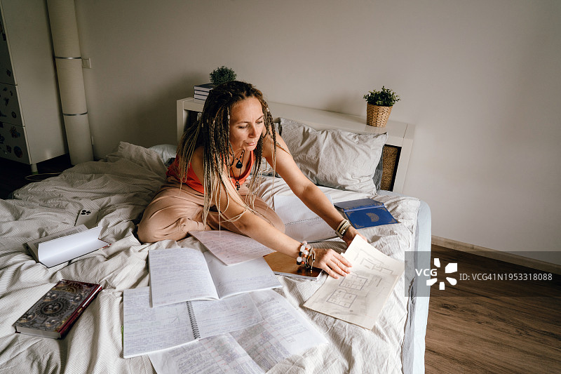 坐在床上用笔记本电脑的女人图片素材