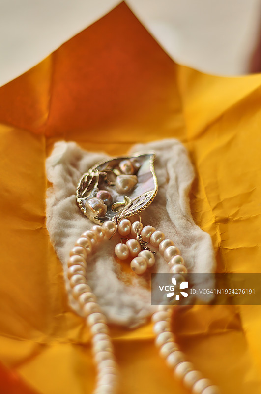 黄色纸上的白色珍珠项链图片素材