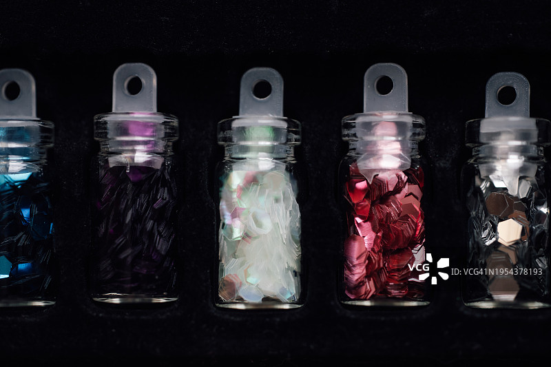 五个带有水钻的小玻璃瓶，黑色背景图片素材