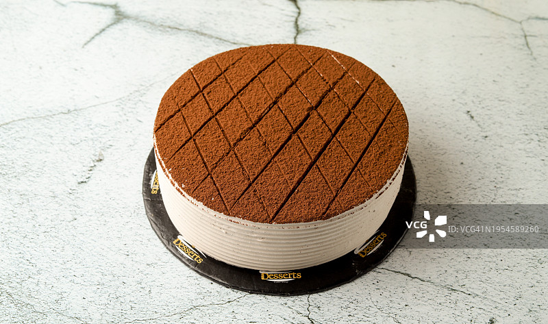在白色大理石背景上供应的巧克力蛋糕图片素材