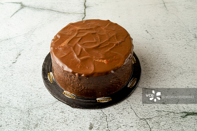 在白色大理石背景上供应的巧克力蛋糕图片素材