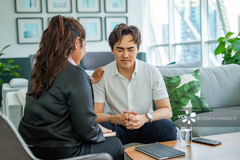 沮丧的年轻人与治疗师交谈图片素材