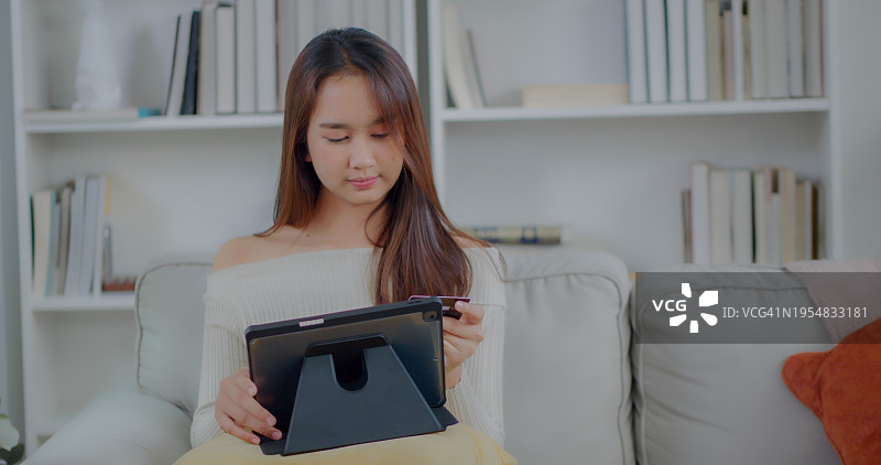 亚洲女性使用手机银行App在线支付购物图片素材