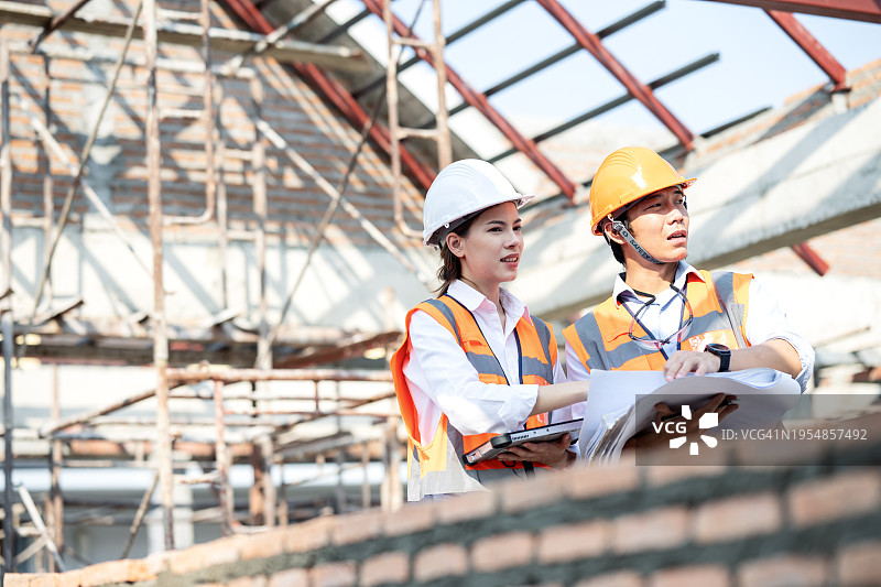 建筑项目成本管理与预算方案：项目负责人与工程师施工现场探讨进展图片素材