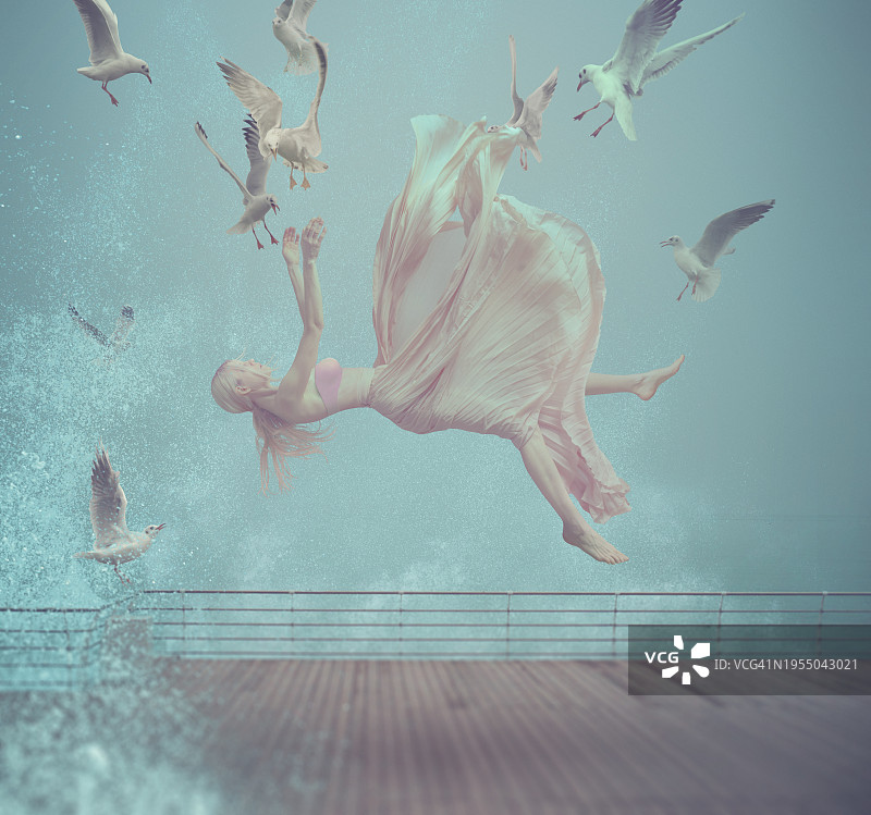 与飞翔的海鸥一起在空中飞翔的年轻女子图片素材