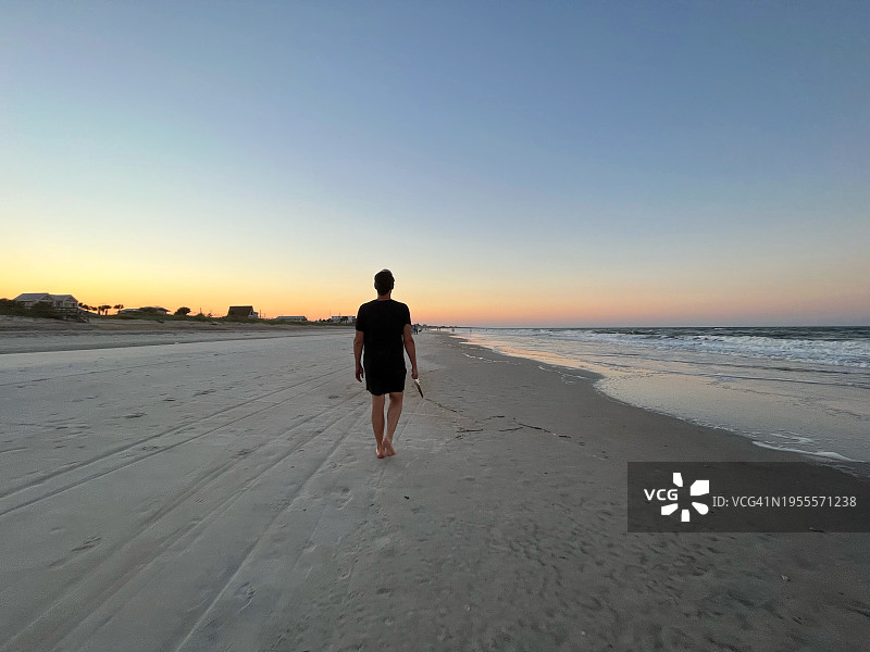 男人在日落时探索海滩图片素材