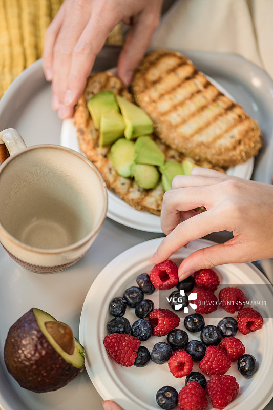 情侣在床上享用美味的早餐，度过安静的周末图片素材